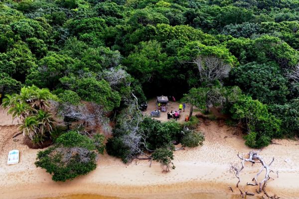 Aerial view of a hiking group resting beside coastal forest at Kosi Bay